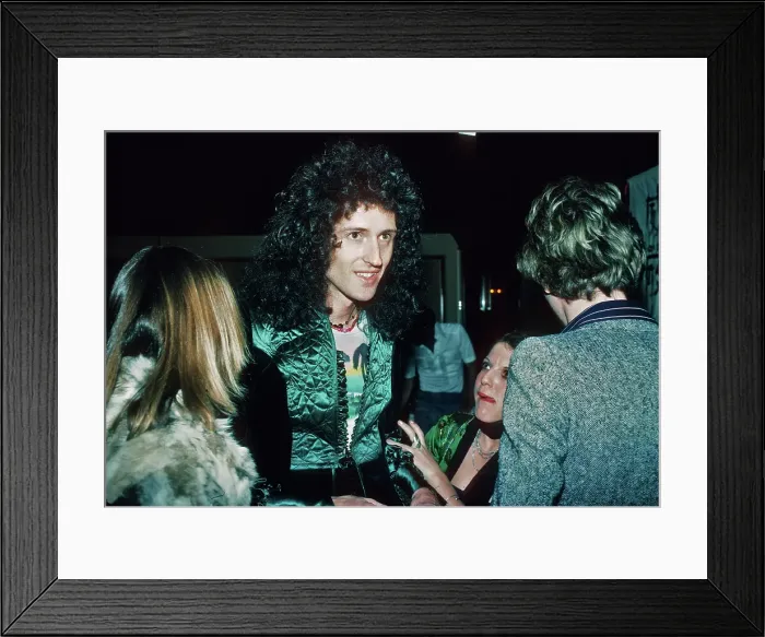 Framed Print : Brian May. Guitarist Brian May of British rock band Queen with fans at a party, March 1977