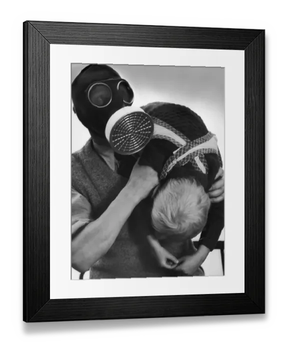 Framed Print : Gas Drill. A man wearing a gas mask and carrying a child over his shoulder