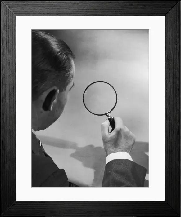 Framed Print : Close Up. circa 1935: A view over a man's shoulder as he looks through a magnifying glass Framed Print : Close Up. circa 1935: A view over a man's shoulder as he looks through a magnifying glass