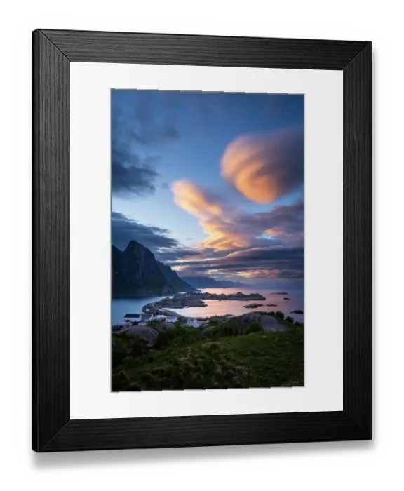 Framed Print : Cloudy landscape. The villages of Olenilsoy, Toppoya (Toppoy) and Hamnoy as well as the mountain Festhaeltinden. View over the sea towards Flakstadoya and Vestvagoya. Several coloured lenticular clouds (lenticularis) in the blue sky