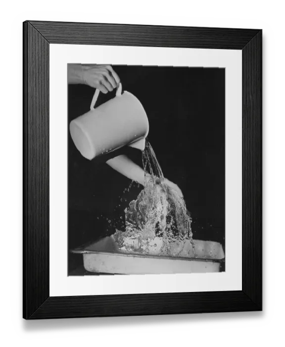 Framed Print : Water Jug. A close up of water being poured out of a water jug, circa 1940s Framed Print : Water Jug. A close up of water being poured out of a water jug, circa 1940s