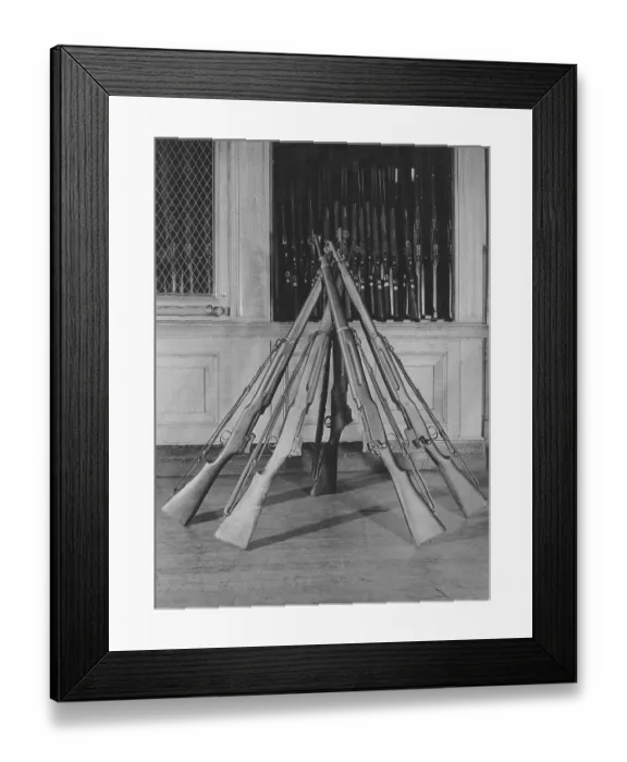 Framed Print : Rifles. Five rifles rest against each other beside a rifle cabinet circa 1940