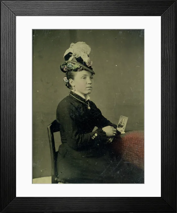Framed Print : Tintype of woman in feathered hat holding a photograph