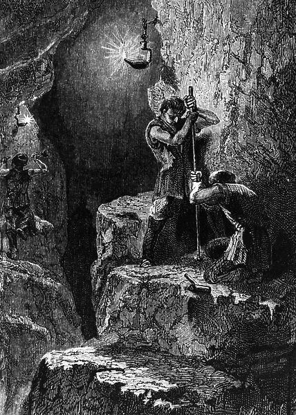Mine On. circa 1790: Two miners work in a mine by the light of an oil lamp