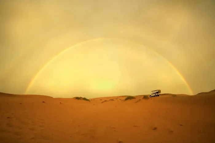 Framed Print : 4X4 Vehicle on a Barren Desert Landscape Under a Rainbow