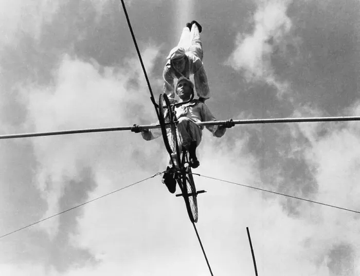 Framed Print : Acrobats on tightrope, low angle view Framed Print : Acrobats on tightrope, low angle view