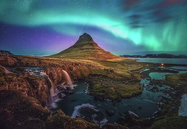 active aurora borealis storm display over iconic shape of mountain kirkjufell, Iceland