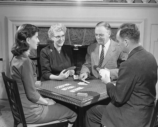 Four adults playing cards