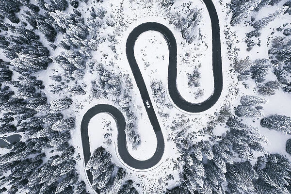 Aerial view of winding road in winter forest