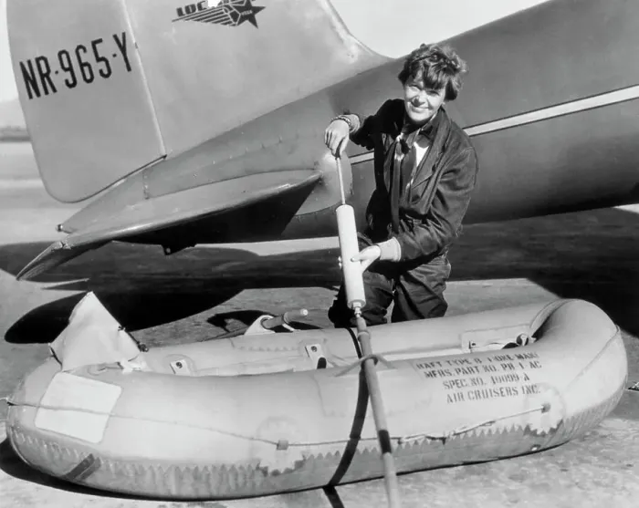 Framed Print : Amelia Earhart Working on Raft Besides Airplane