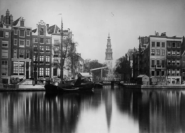 Amsterdam. circa 1900: A barge moored alongside a canal in the Dutch city of Amsterdam
