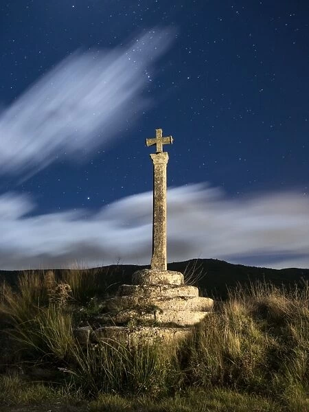 Ancient monument of medieval epoch in the shape of cross, illuminated by the moonlight