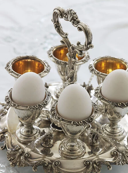 Antique silver egg cups in a sophisticated environment #12550327