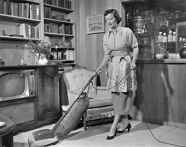 Apron housewife vacuuming den