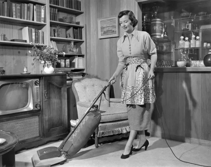 Framed Print : Apron housewife vacuuming den Framed Print : Apron housewife vacuuming den