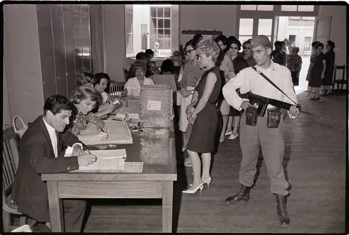 Framed Print : Armed Guard Watches Voters Cast Ballots
