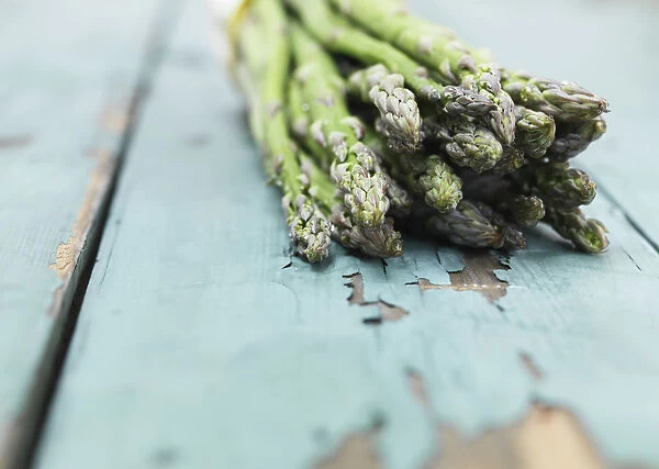 Asparagus photographed against a painted green wood background