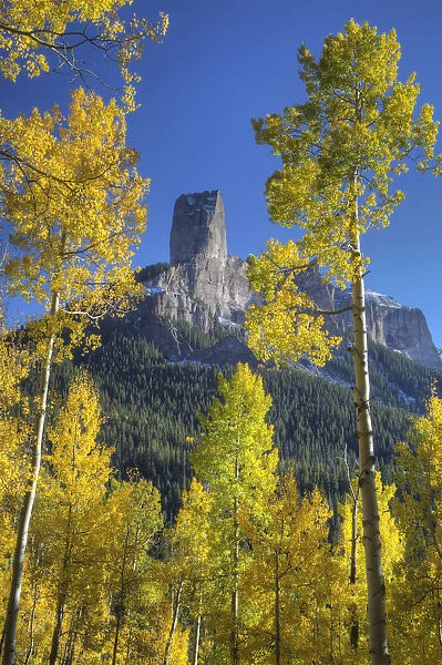 Aspen trees frame chimney rock formation, San Juan Mountains, Colorado, USA