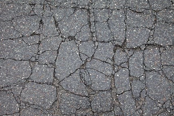 Asphalt cracked by frost and cold, potholes in Berlin, Germany, Europe