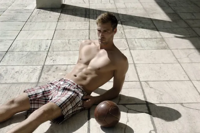 Framed Print : Athletic young man in shorts with ball lying on a stone floor Framed Print : Athletic young man in shorts with ball lying on a stone floor