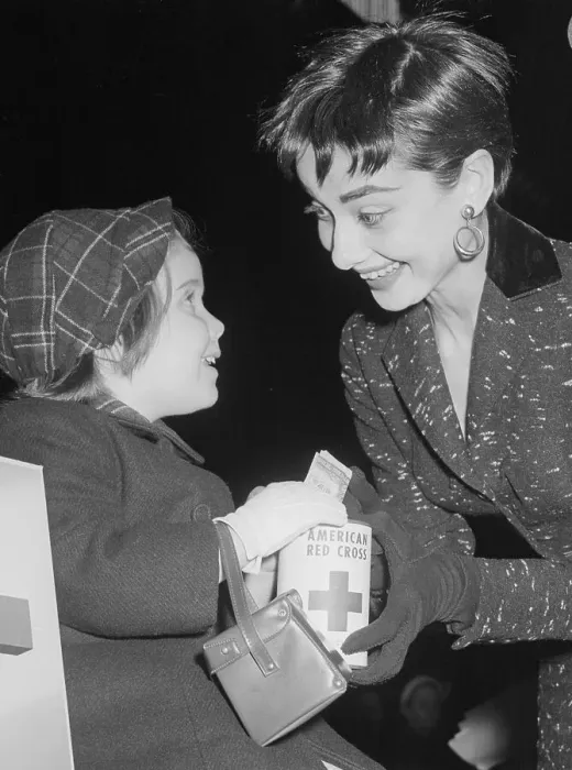Framed Print : Audrey Hepburn with Girl Donating to Red Cross Framed Print : Audrey Hepburn with Girl Donating to Red Cross