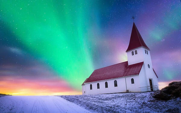 aurora borealis over the church landing on the hill covered by snow, Vik i myrdal church