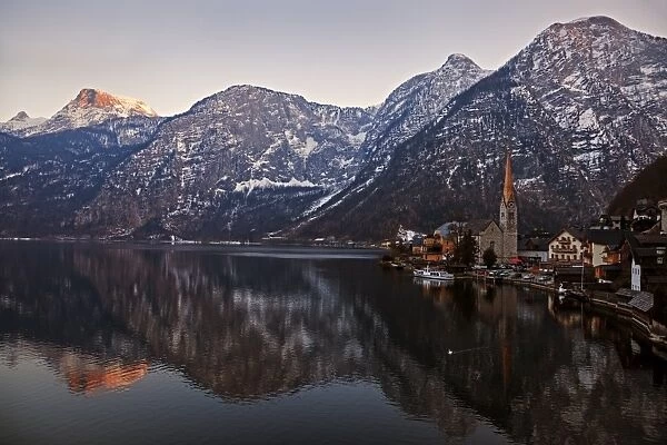 Austria, Hallstatt, Town and mountains reflecting in lake