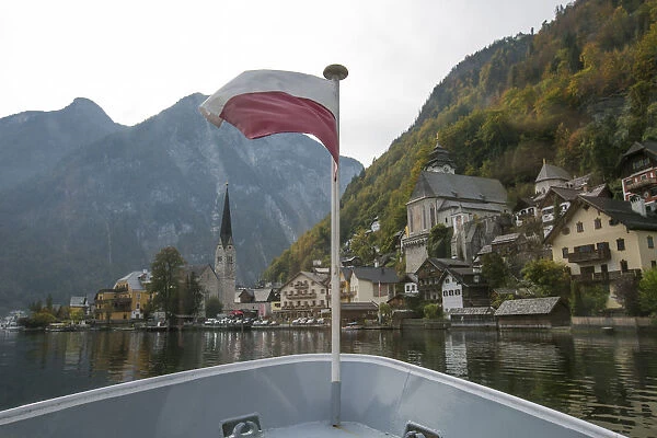 Austrian flag at stern of a ship on Lake Hallstatt, Hallstatt in background, Salzkammergut, Upper Austria, Austria