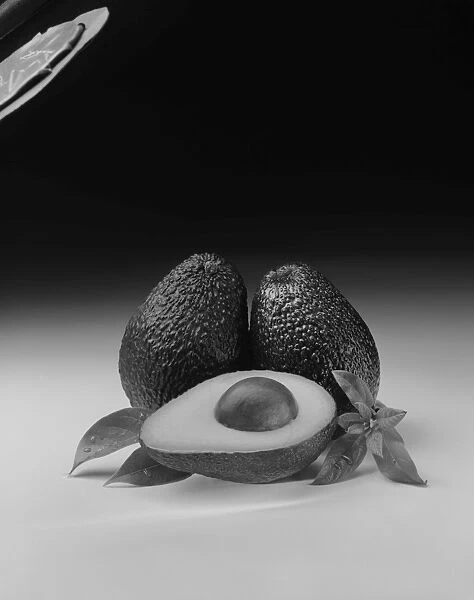 Avocados with leaf on white background, close-up