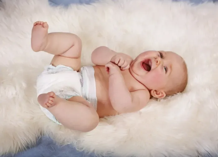 Framed Print : Baby, 5 months, lying on his back, on sheepskin rug, laughing, Germany