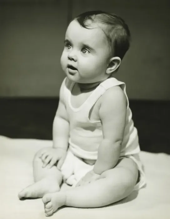 Framed Print : Baby boy (12-18 months) sitting on bedspread, (B&W), close-up Framed Print : Baby boy (12-18 months) sitting on bedspread, (B&W), close-up