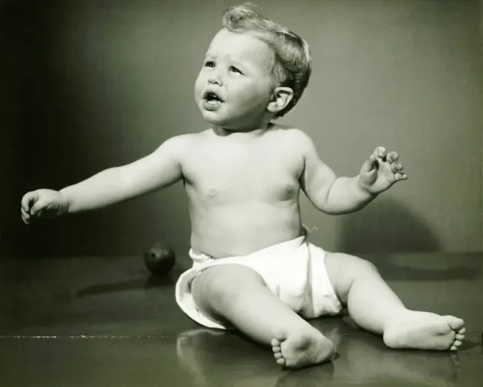 Framed Print : Baby boy (6-12) in nappy sitting on floor, (B&W)