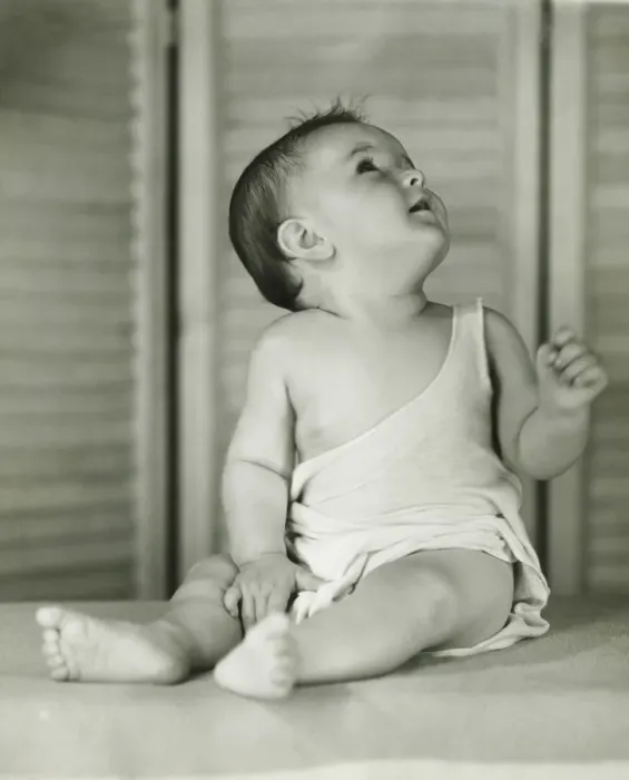 Framed Print : Baby boy (6-12) sitting on floor indoors, looking upwards, (B&W) Framed Print : Baby boy (6-12) sitting on floor indoors, looking upwards, (B&W)