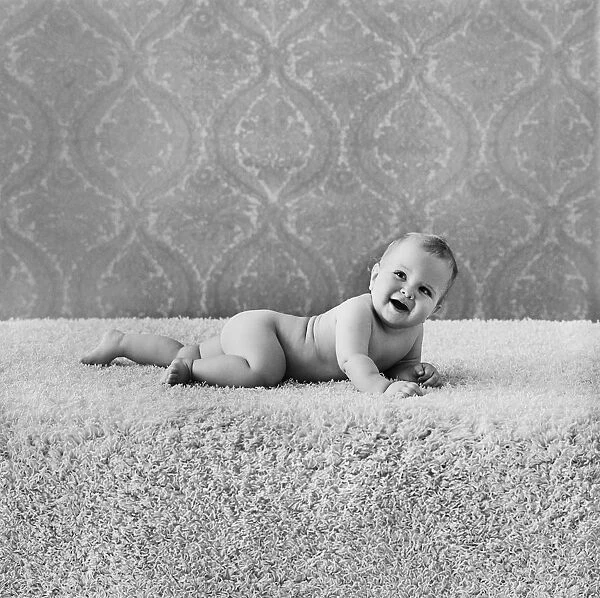 Baby boy lying on rug, smiling