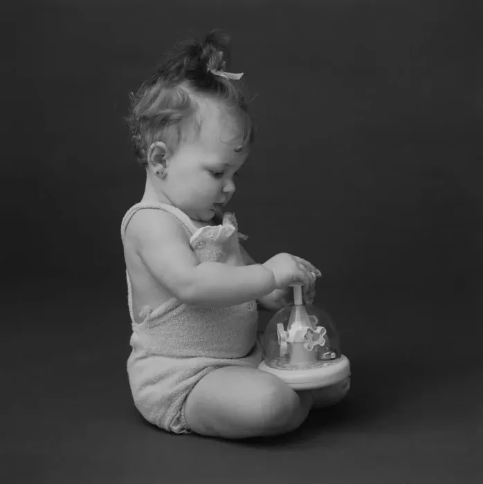 Framed Print : Baby girl playing with toy, close-up Framed Print : Baby girl playing with toy, close-up