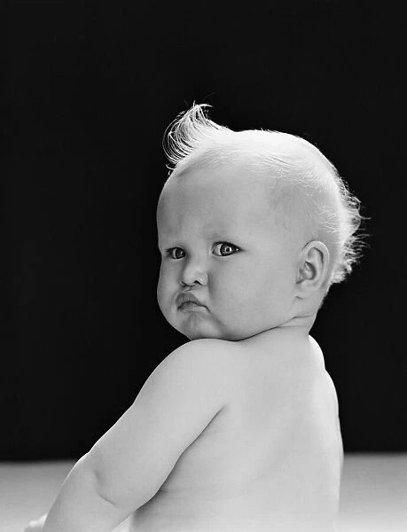 Baby looking over shoulder, with angry expression