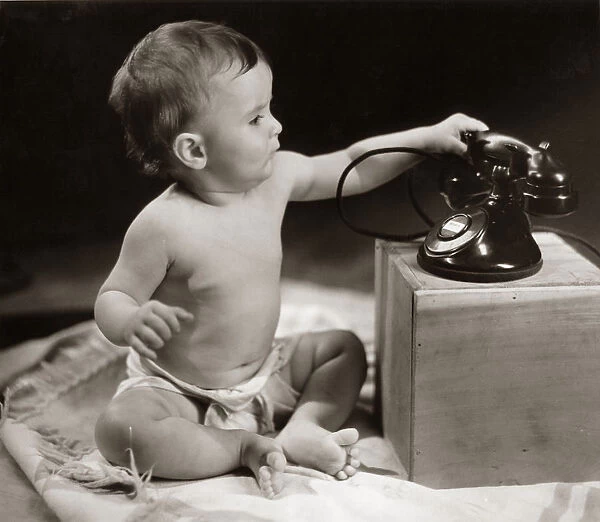 Baby picking up telephone receiver