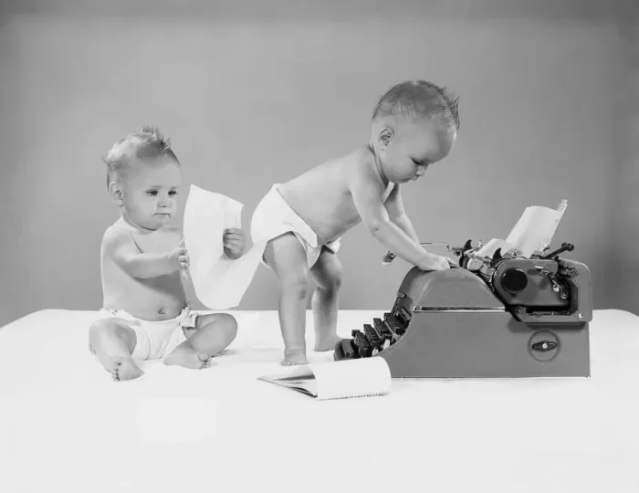 Framed Print : Baby standing at typewriter, twin seated behind looking at papers Framed Print : Baby standing at typewriter, twin seated behind looking at papers
