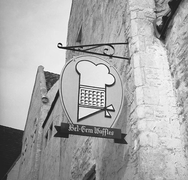 Bakery sign hanging on wall, (B&W), low angle view