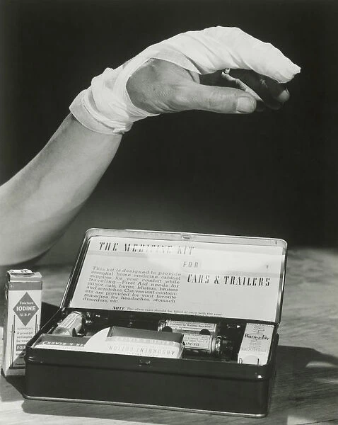 Bandaged arm next to first aid kit