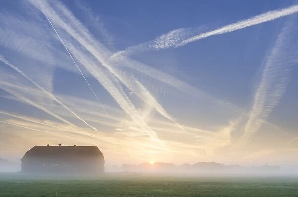 Barn, condensation trails in the sky, sunrise in Basse, Lake Mariensee, Neustadt am Ruebenberge, Lower Saxony, Germany, Europe