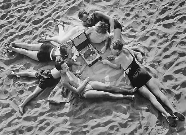Beach Music. A group of people lying on a sandy beach