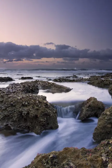 Framed Print : Beautiful soft colour sunrise over the sea with rocks in the foreground - Cape Vidal South Africa
