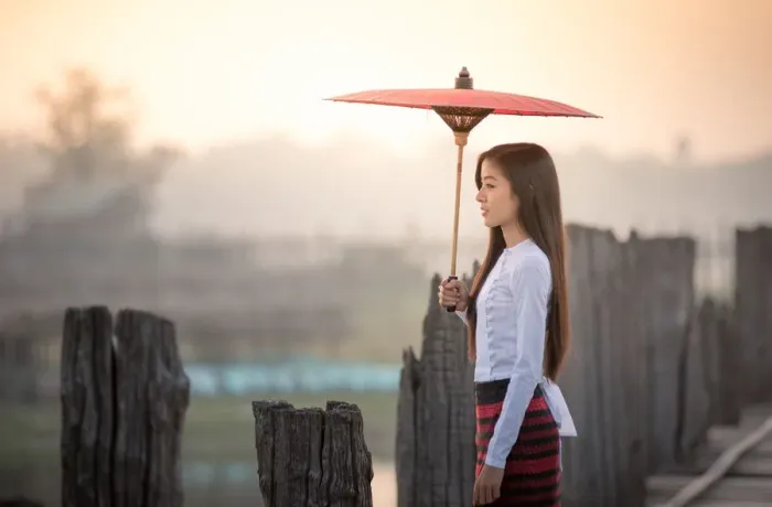 Framed Print : Beautiful woman holding traditional red umbrella and walking on U Bein Bridge, Myanmar Framed Print : Beautiful woman holding traditional red umbrella and walking on U Bein Bridge, Myanmar
