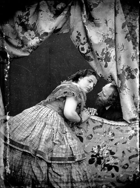 Bed Chat. circa 1865: A young woman leaning across the end of a bed to
