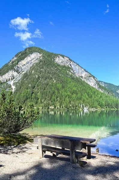 Empty bench looking at Lake Braies on a perfect sunny day, South Tyrol, Italy
