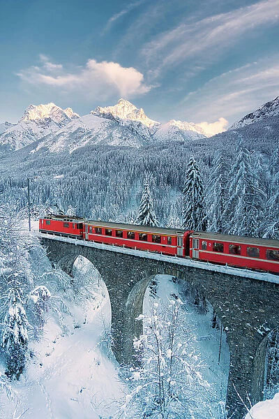 Bernina Express train in the snowy forest, Switzerland