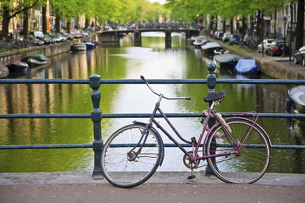 Bicycle on a bridge crossing a canal in the historic city centre of Amsterdam, Holland, Netherlands, Europe