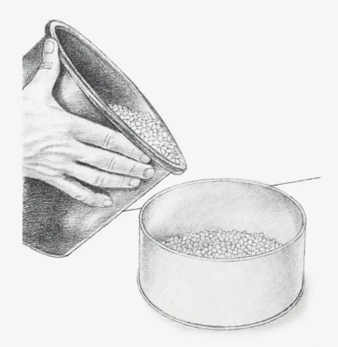 Framed Print : Black and white illustration of hand holding bucket of blue silica gel crystals and pouring into base of biscuit tin (drying flowers using desiccant)