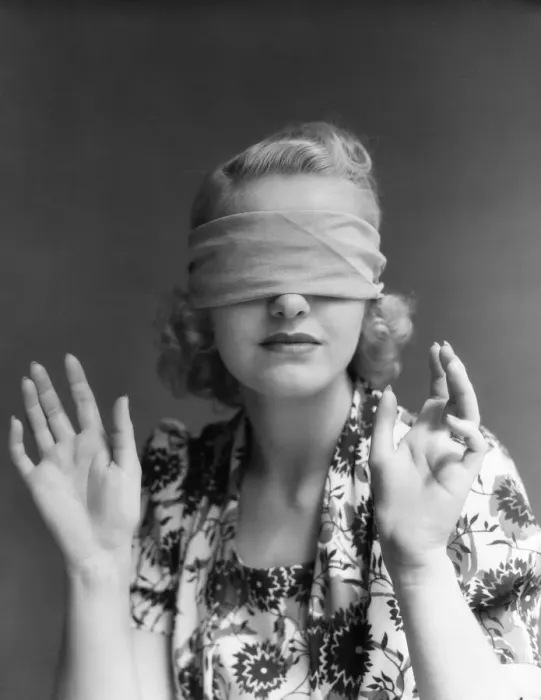 Framed Print : Blindfolded woman holding hands out in front of herself. (Photo by H